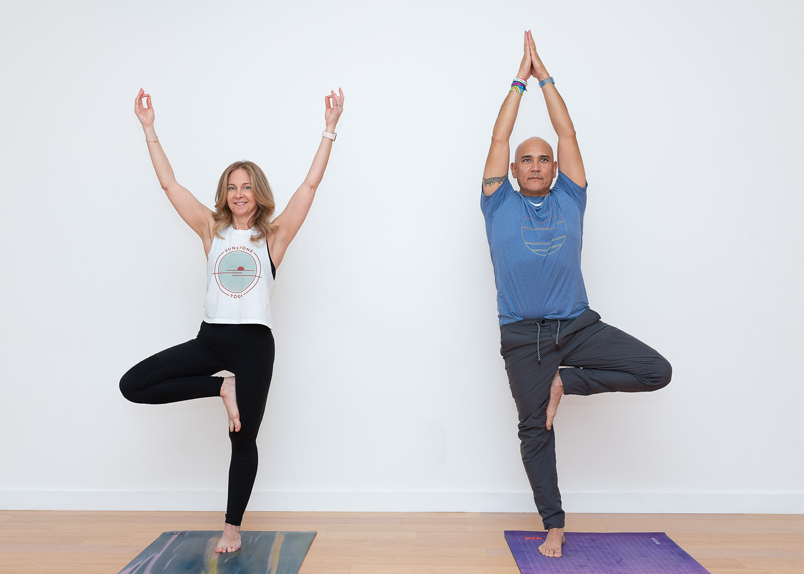 Two students in tree pose inside Sunstone Yoga's Westchester studio