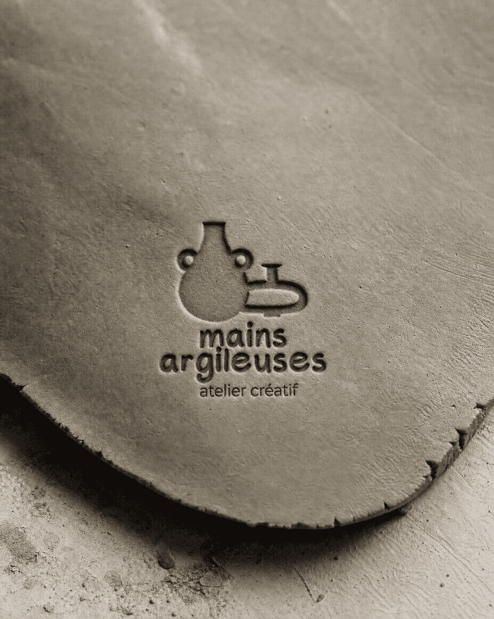 logotype Mains Argileuses, identité visuelle de céramiste, blanc sur fond brun olive.
