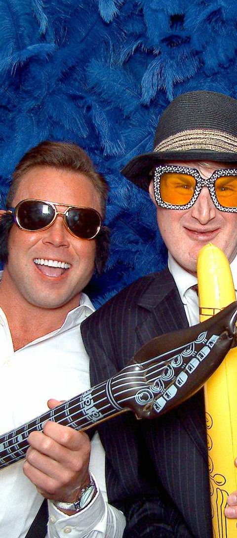 Two men in costumes, one with guitar, one with banana