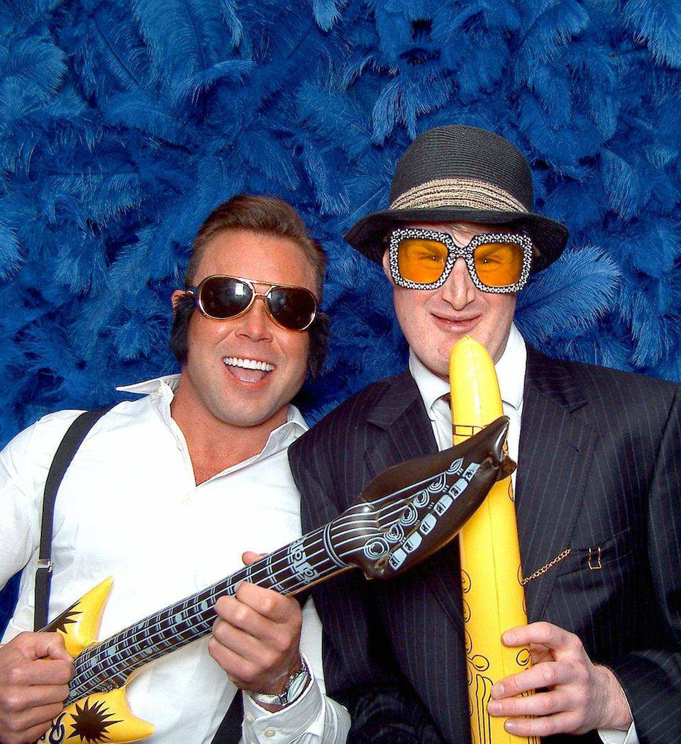 Two men in costumes, one with guitar, one with banana