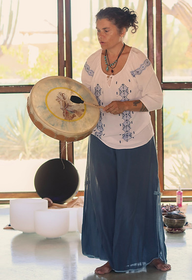 Aria Walker, L.Ac. playing a drum during sound healing and shamanic work.