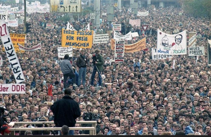 1989년 11월 4일 동베를린 알렉산더 광장의 시위 모습. 당시 시위 주최 측과 현장 취재진은 최대 100만 명이 시위에 참가한 것으로 보도했다. 5일 후인 11월 9일에 베를린 장벽이 개방되었고, 동독의 공산당 정권은 1990년 3월에 자유 총선거를 실시한 후 몰락했다. 동독의 시민운동가들은 시위 초기에 독일 통일이 아닌 ‘진정한 사회주의’를 추구했다. 그러나 이런 구호는 점차 많은 시민들에 의해서 ‘독일 통일’로 바뀌게 되었다.