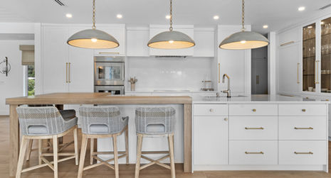 Modern kitchen design with island, pendant lights, and bar stools Delorie Countertop and Doors