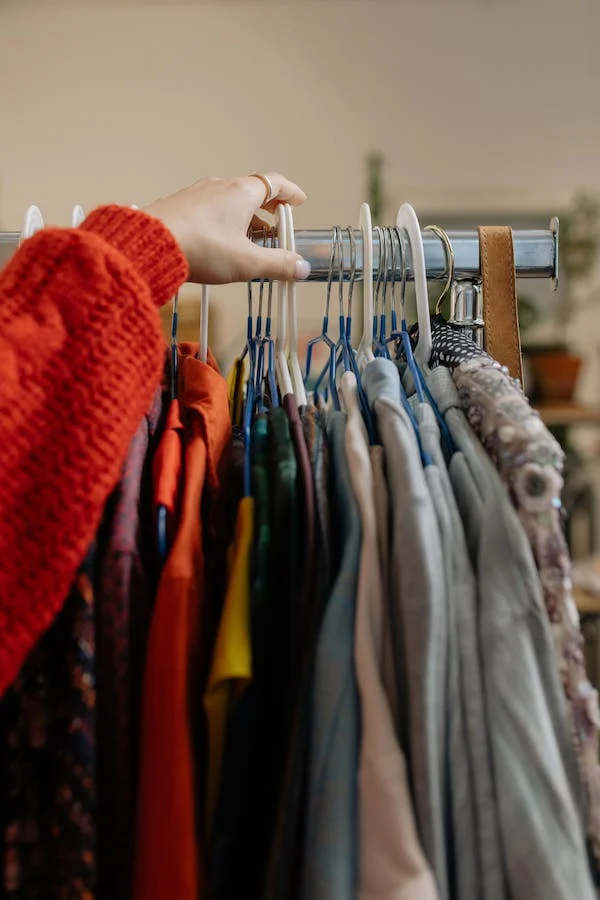 A rail of clothes in a charity shop