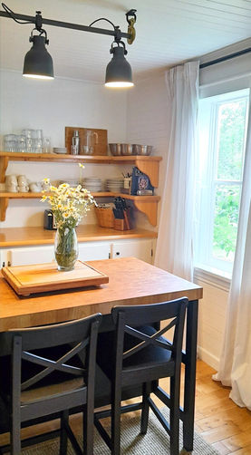 Two barstools at contemporary kitchen island in old-fashioned Old Salt Cottage.