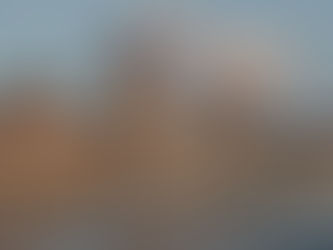 The Hungarian Parliament building from outside with 2 boats on the Danube and a few clouds.