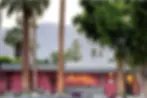 Hot pink mid-century modern hotel exterior with palm trees in Palm Springs, ideal base for an LA to Palm Springs road trip