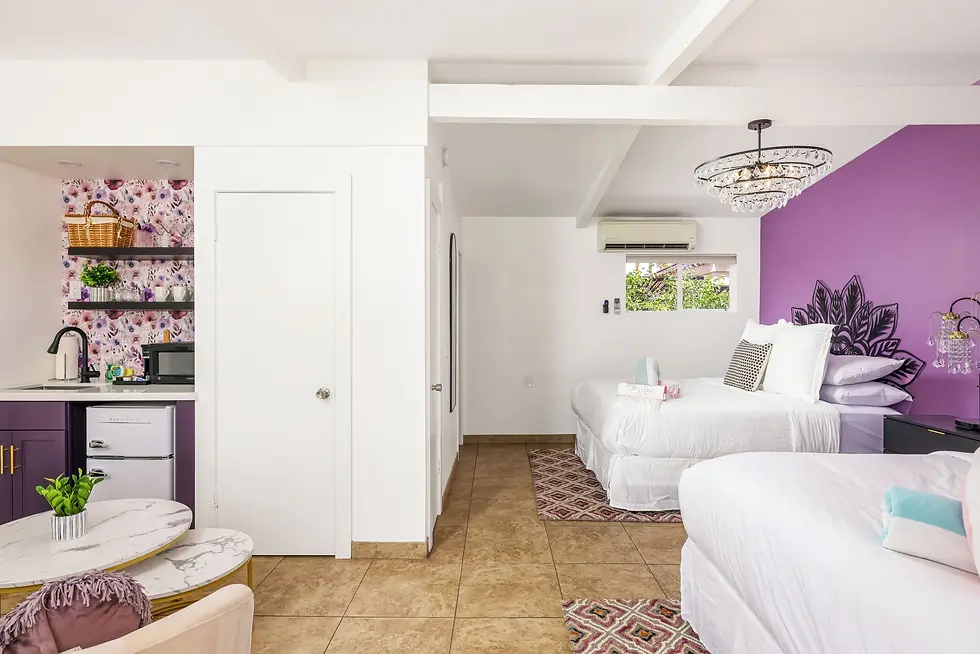 Modern purple suite bedroom with queen beds and kitchenette at The Muse Hotel Palm Springs