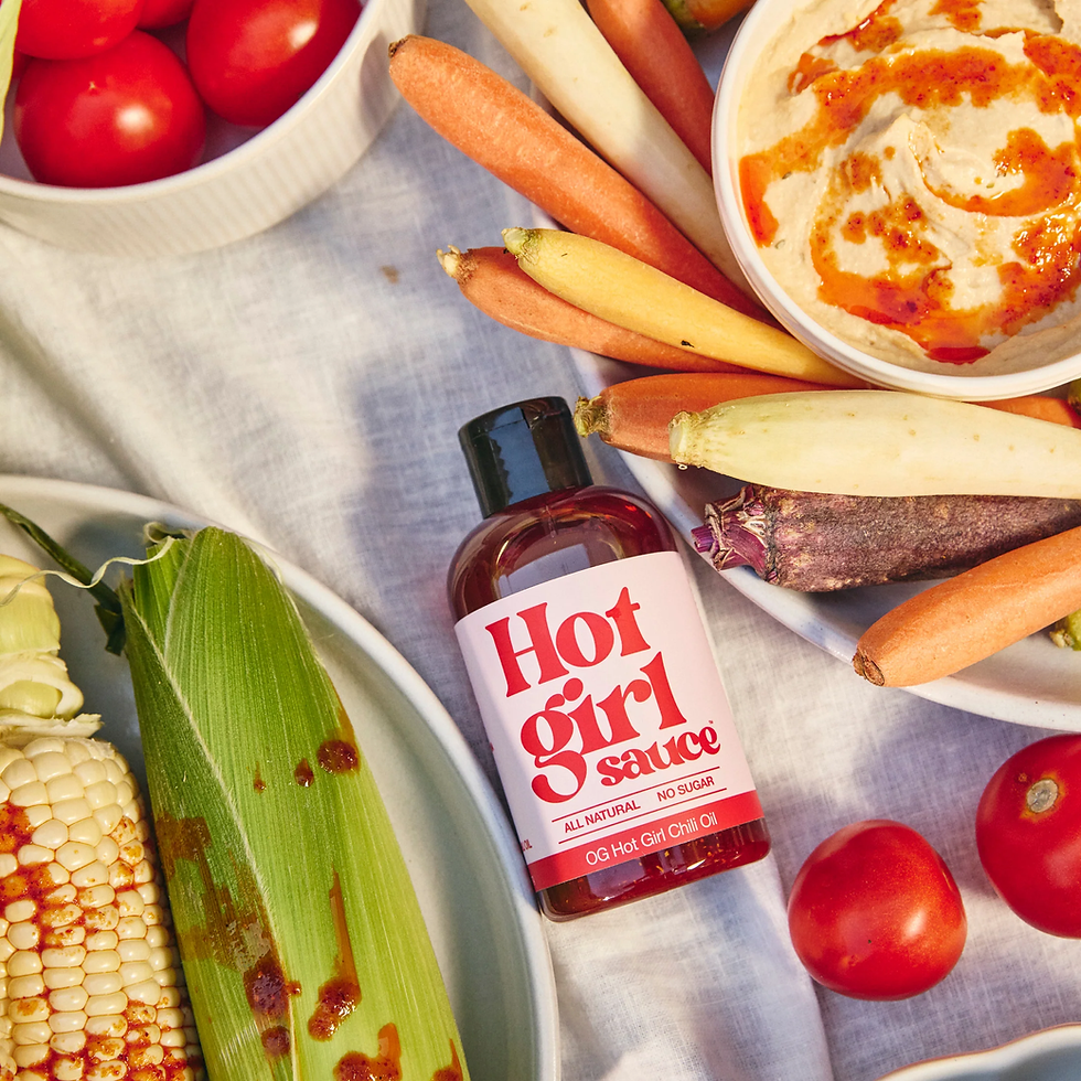 Flatlay of ramen, Korean chips, and Hotgirlsauce jars on a linen-covered table