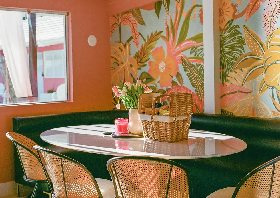 Vibrant Palm Springs hotel dining area with botanical wallpaper, round white table, and colorful decor perfect for