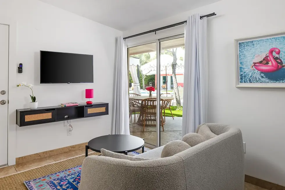 Modern living room with curved beige sofa and patio access perfect for a desert pool party birthday getaway celebration