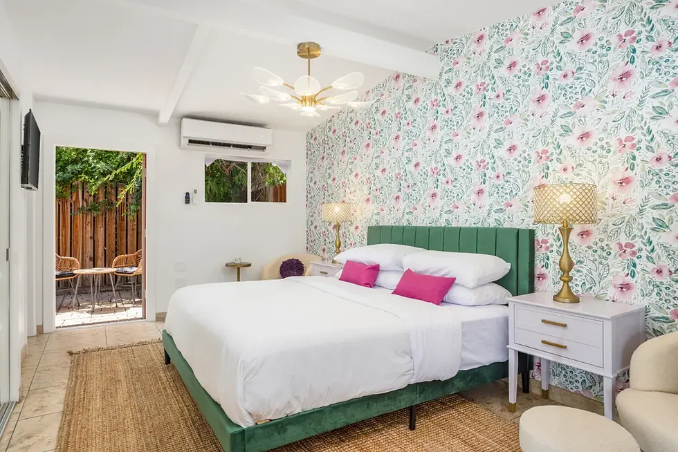 Modern Brigitte Suite bedroom with green velvet bed and floral wallpaper in Palm Springs