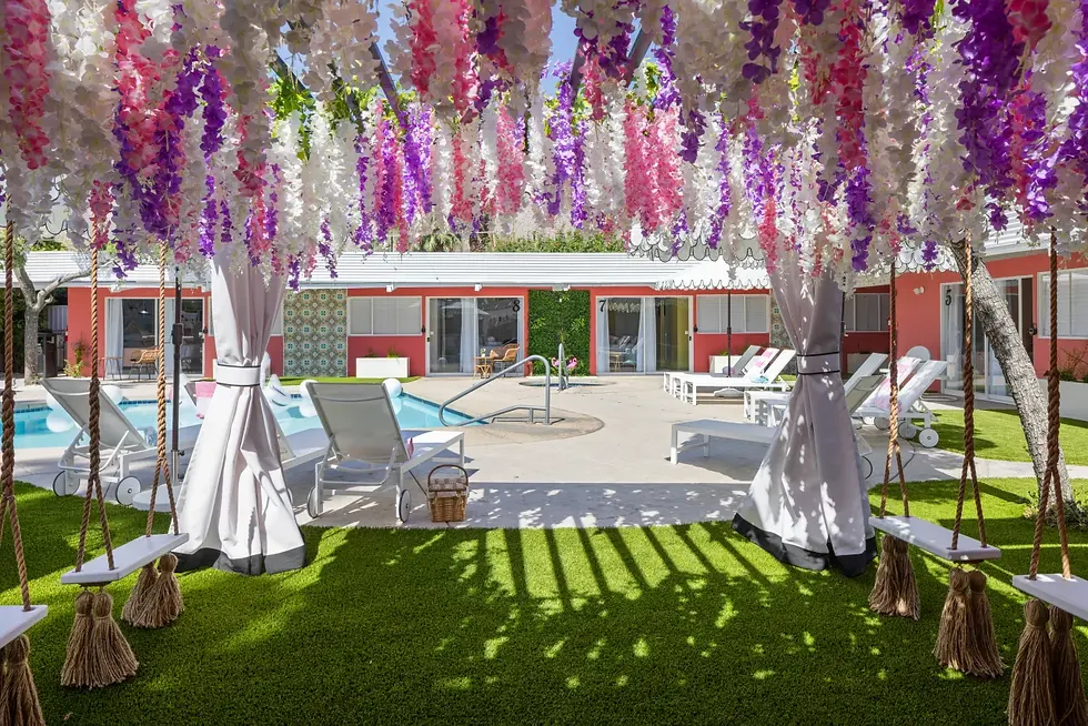 Luxury poolside celebration setup with cascading wisteria flowers, lounge chairs, and sparkling pool at resort