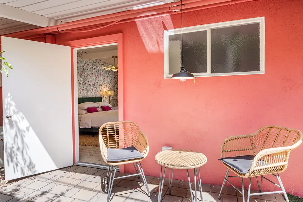 Coral-pink suite entrance with rattan chairs at The Muse Hotel Palm Springs, boutique hotel base for Palm Springs activities