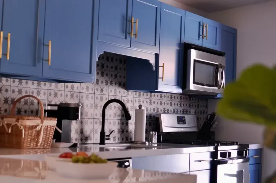 Modern kitchen with blue cabinetry, star backsplash, and stainless steel appliances at The Muse Hotel Palm Springs