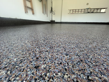 Modern finished garage with epoxy flooring and organized storage, showing how garage upgrades increase home value and functionality.