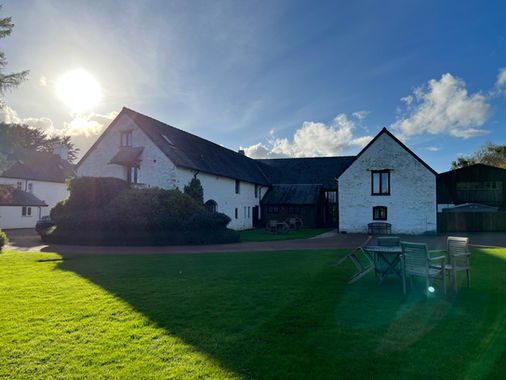 Sunshine and blue skies above white washed cottages at wellbeing retreat venuw