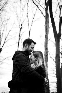 Couple in a romantic black and white portrait among bare winter trees