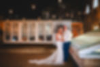 Couple posing together outside the Kings Head Cirencester with string lights at night during evening reception photos