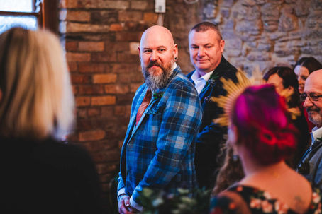 Grooms reaction to bride walking down the aisle taken from a second photographers perspective at The Radnor Rooms in Bristol