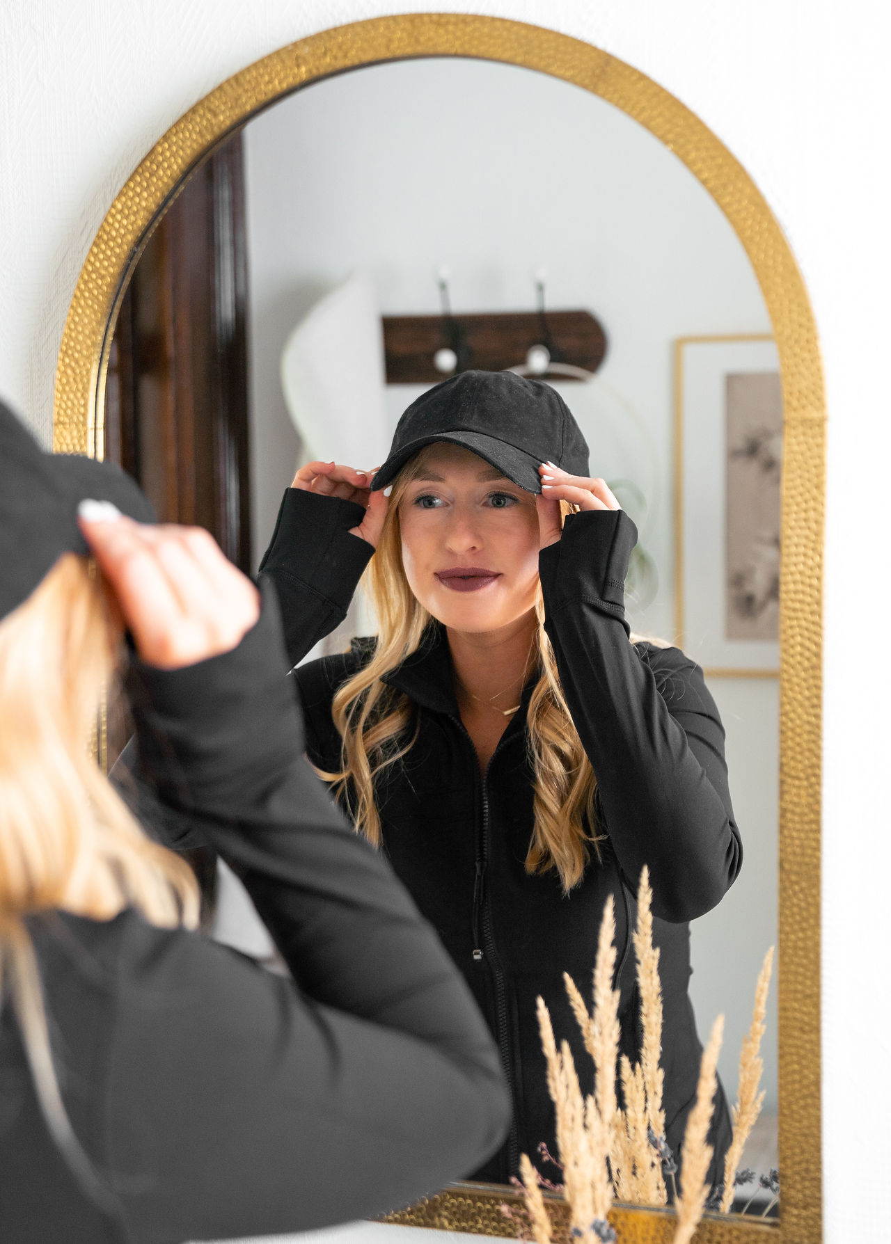 our skin nutritionist putting on a hat in a mirror