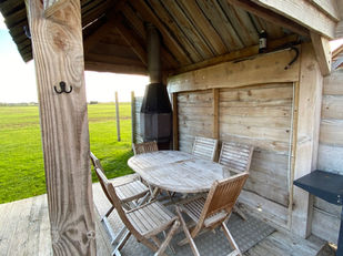 Outdoor area with countryside field view, BBQ and outdoor log burner.