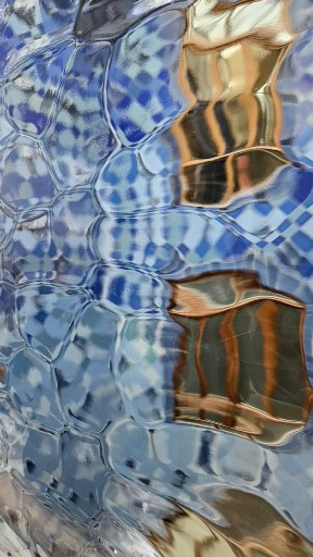 Glass wall as seen through wavy colored glass panel, Casa Vicens, Barcelona, Spain.a
