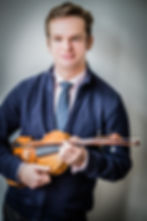 Violinist Savva Zverev holding his violin, studio portrait