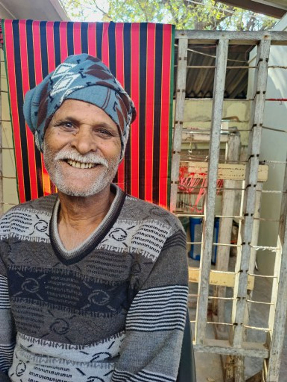 Devji Ravji standing in front of his local shop.