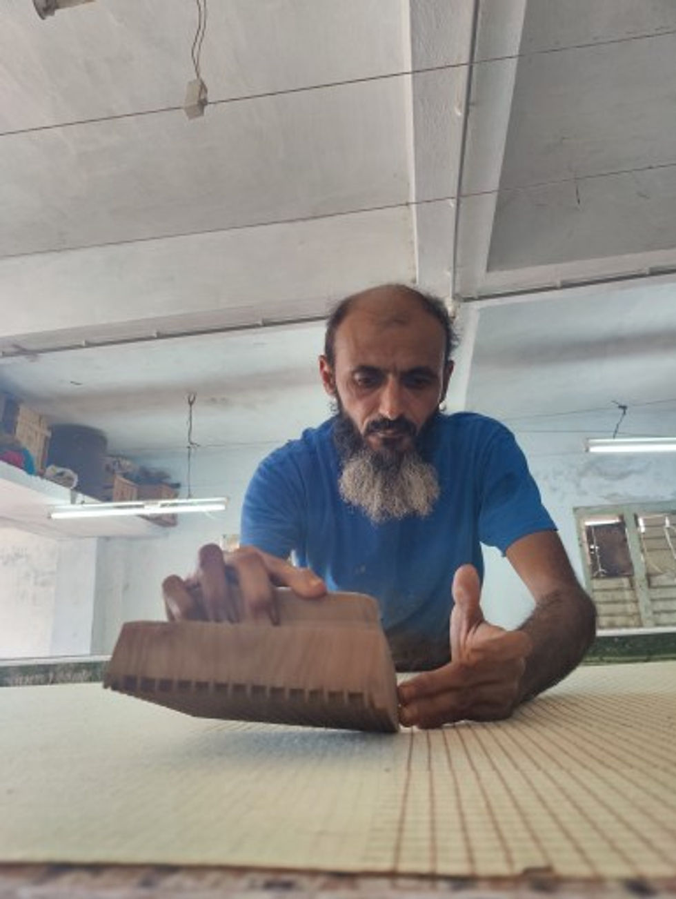 Artisan creating a block print on a sheet with meticulous precision.