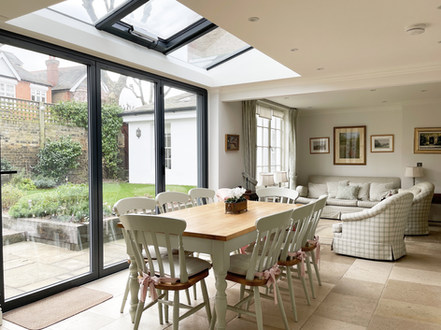 a charming mix of old and new
vintage kitchen table and chairs are positioned under the roof lights
the expanse of bifold doors have the effect of bringing the outdoors in
