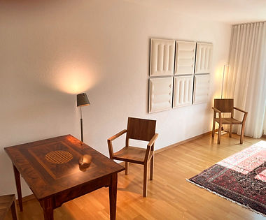 Einladender Hypnotherapie-Raum in Bern mit Holztisch und Akustikpaneelen – ruhige Atmosphäre für persönliche Gespräche.