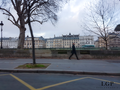 Scène de rue à Paris avec un passant en mouvement, photographié de manière artistique et floue.
