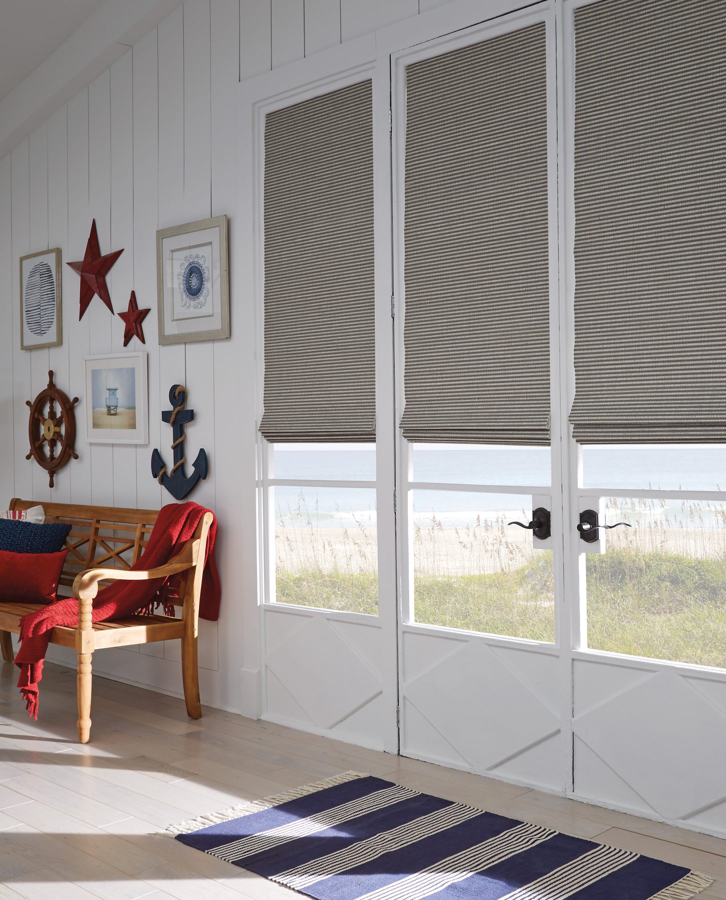 Natural woven Roman shades in a coastal-style room