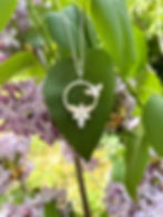 Collier en argent représentant une abeille et une fleur, vu de face.