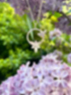 Collier en argent représentant une abeille et une fleur, vu de face.