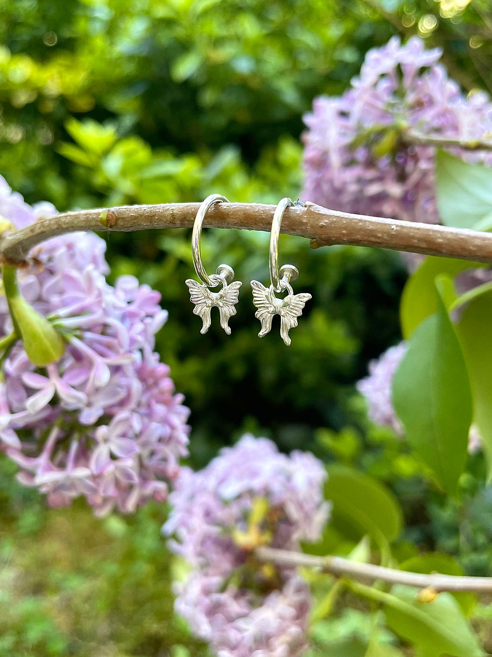 Mini créoles en argent, avec un pendentif en forme de papillon, vues de face.