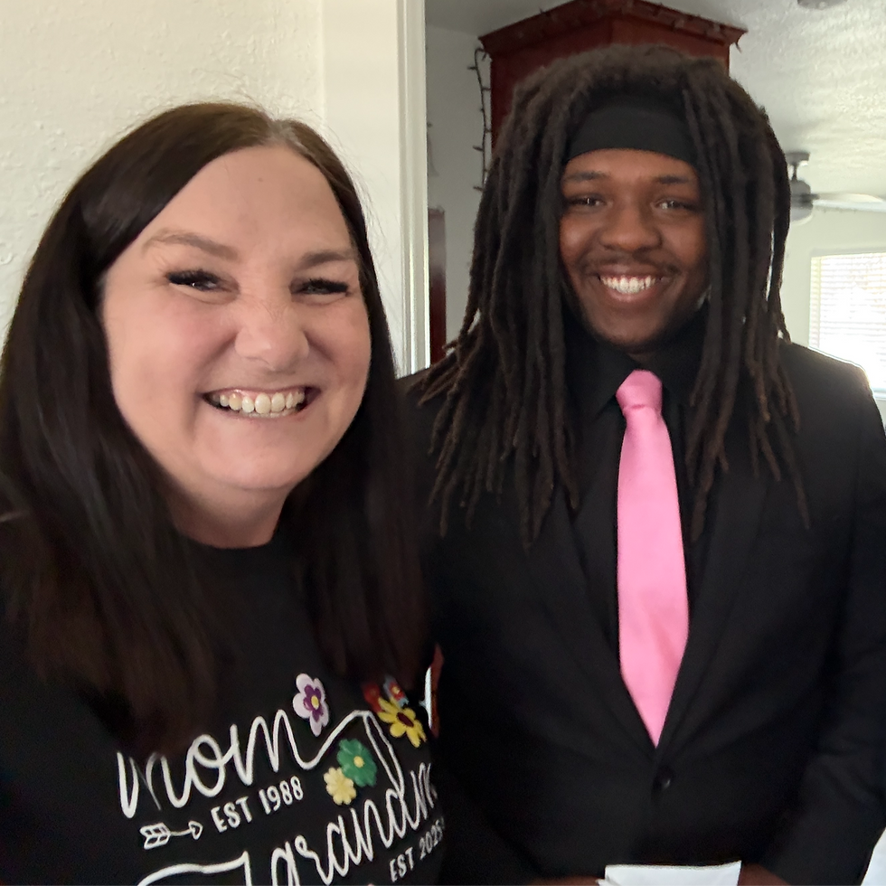 A student proudly shows off his stylish new suit to Jenny, sharing a moment of joy and celebration.