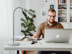 Small business owner working at a dedicated home office desk that qualifies for the home office tax deduction