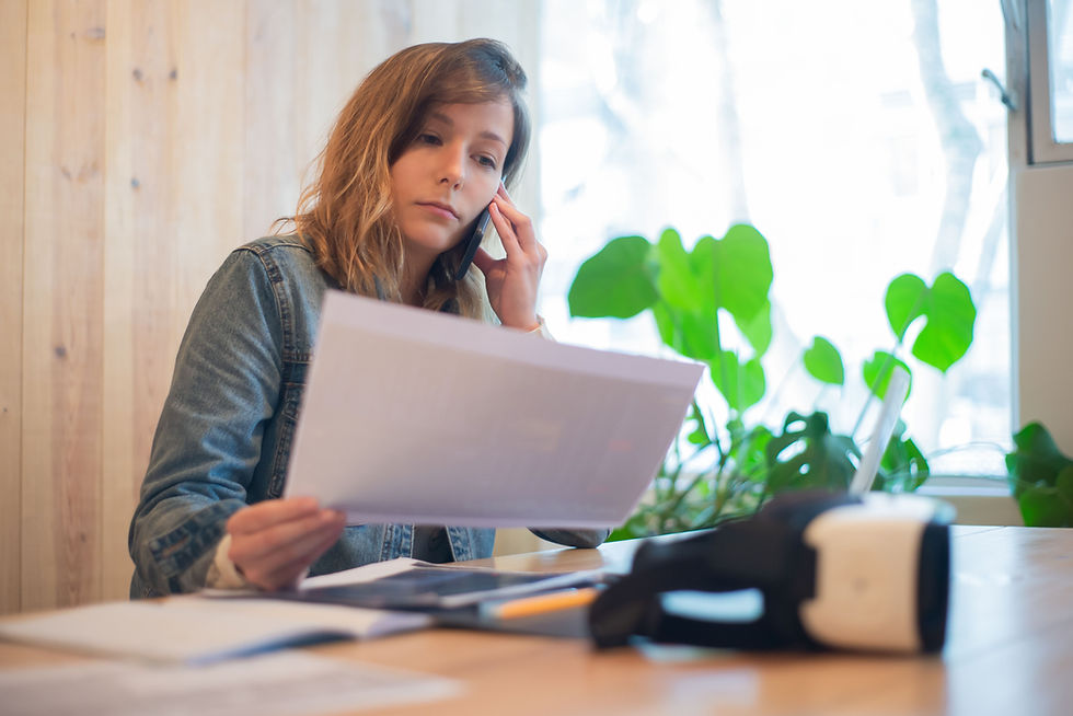 Small business owner reviewing payroll for small business paperwork on the phone"