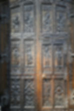 Intricately carved wooden doors inside St. Vitus Cathedral in Prague with detailed figures and ornaments