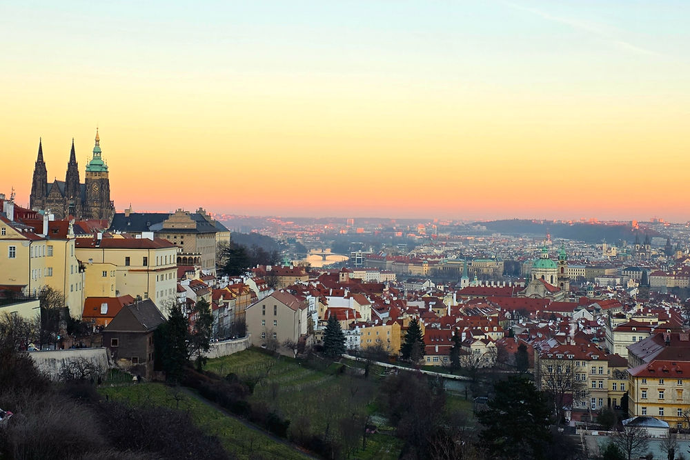 Pastel sunset over Prague Castle and city skyline viewed from Raoul Wallenberg Promenade