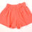 Thumbnail: Shorts in orange material. Elasticated waist. Frill at bottom edge of waistband.9-12 months.