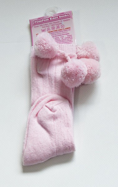 Thumbnail: Socks have rib design on legs and top of feet. 2 pom pom near top of leg.