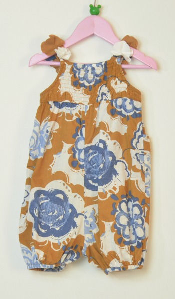 Thumbnail: Bottom section gathered onto bodice.4 stud fastening underneath. 2 pockets on front. Blue and white floral on tan background.