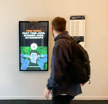 Man walking by a digital display poster