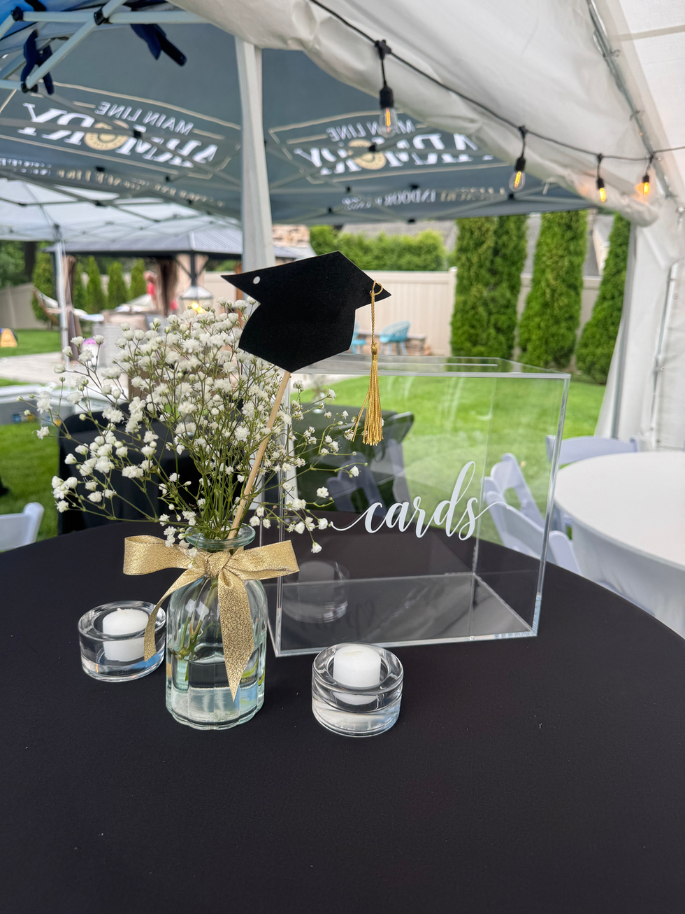 Clear cards box, baby's breath, and graduation cap centerpiece.