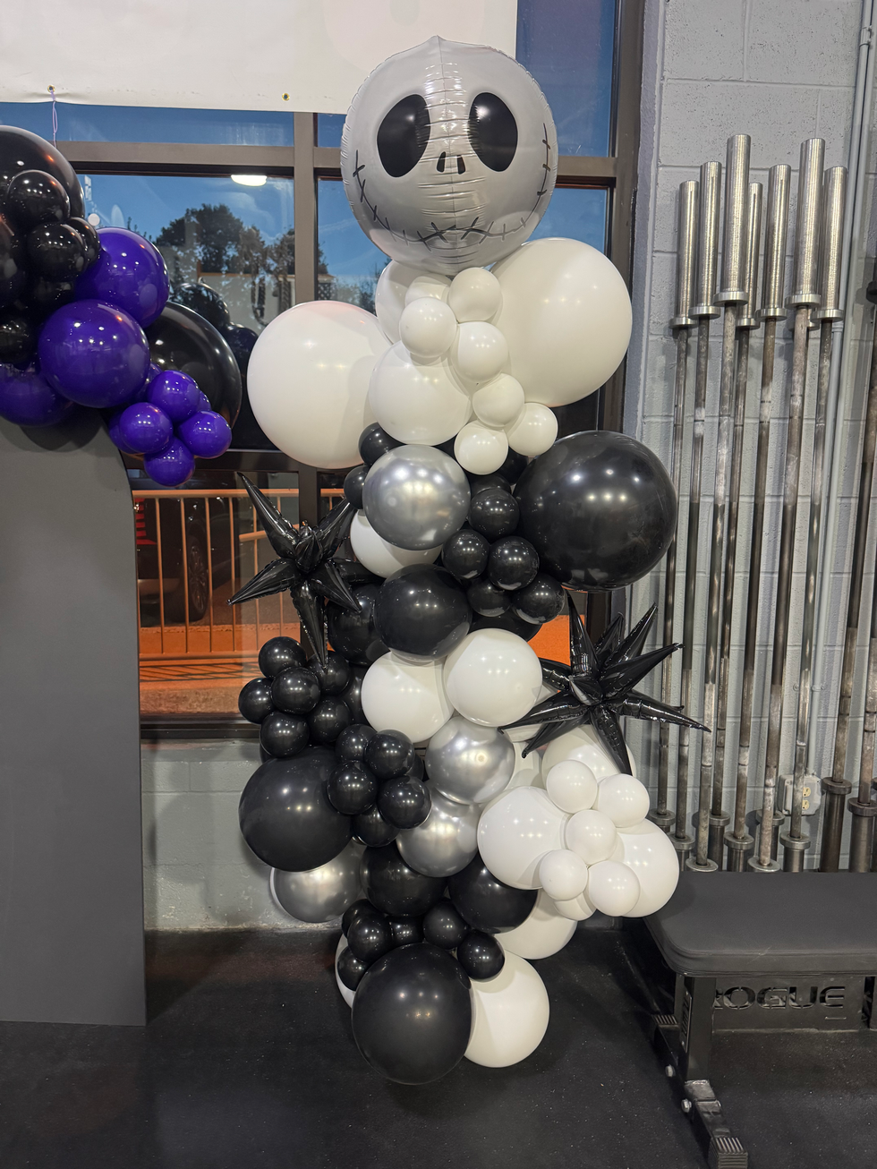 Vertical balloon pillar in black, white, and silver with a skull head