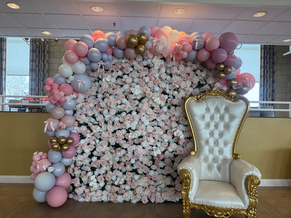 Floral wall backdrop with balloons and ornate throne chair