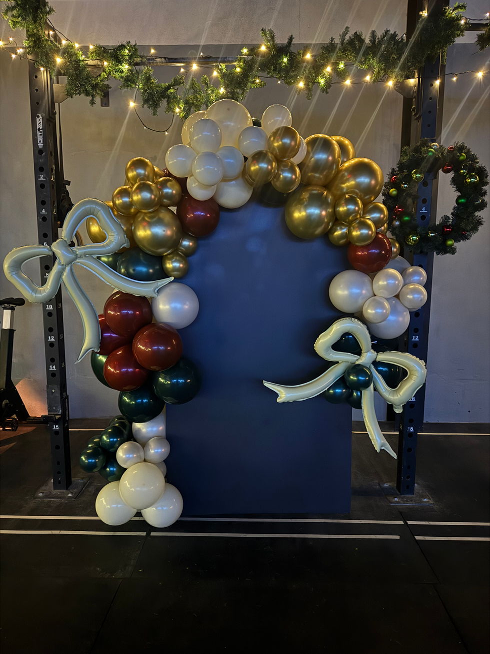 Holiday party balloon arch with bows and a wreath